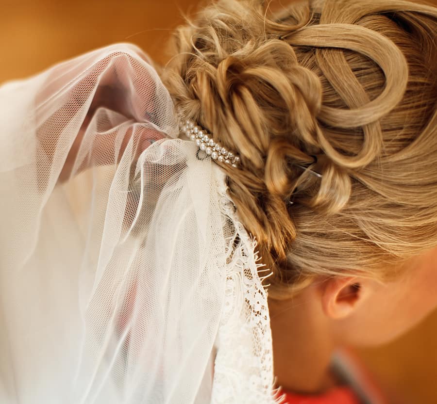 Bridal veil is put on a lady's hair